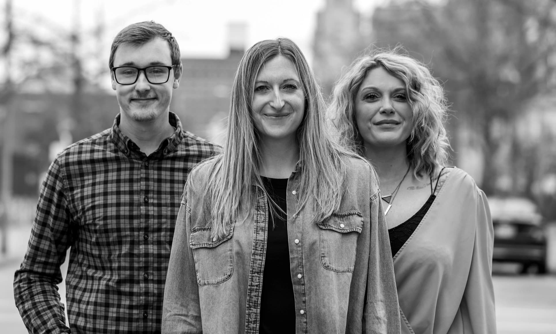 Image of 3 people staring at the camera in the street